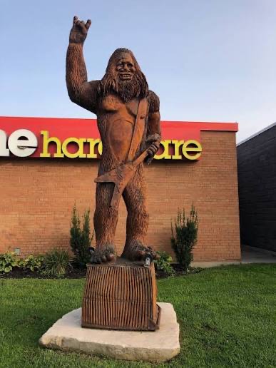 Sasquatch wood carving on a pedestal outside Home Hardware